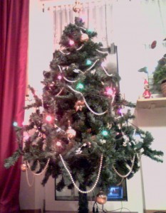 Weihnachtsbaum (mit Lichterkette, zwei Ketten mit Weihnachtsmotiven, einer Perlenkette, Goldbl�ten und Weihnachtskugeln)